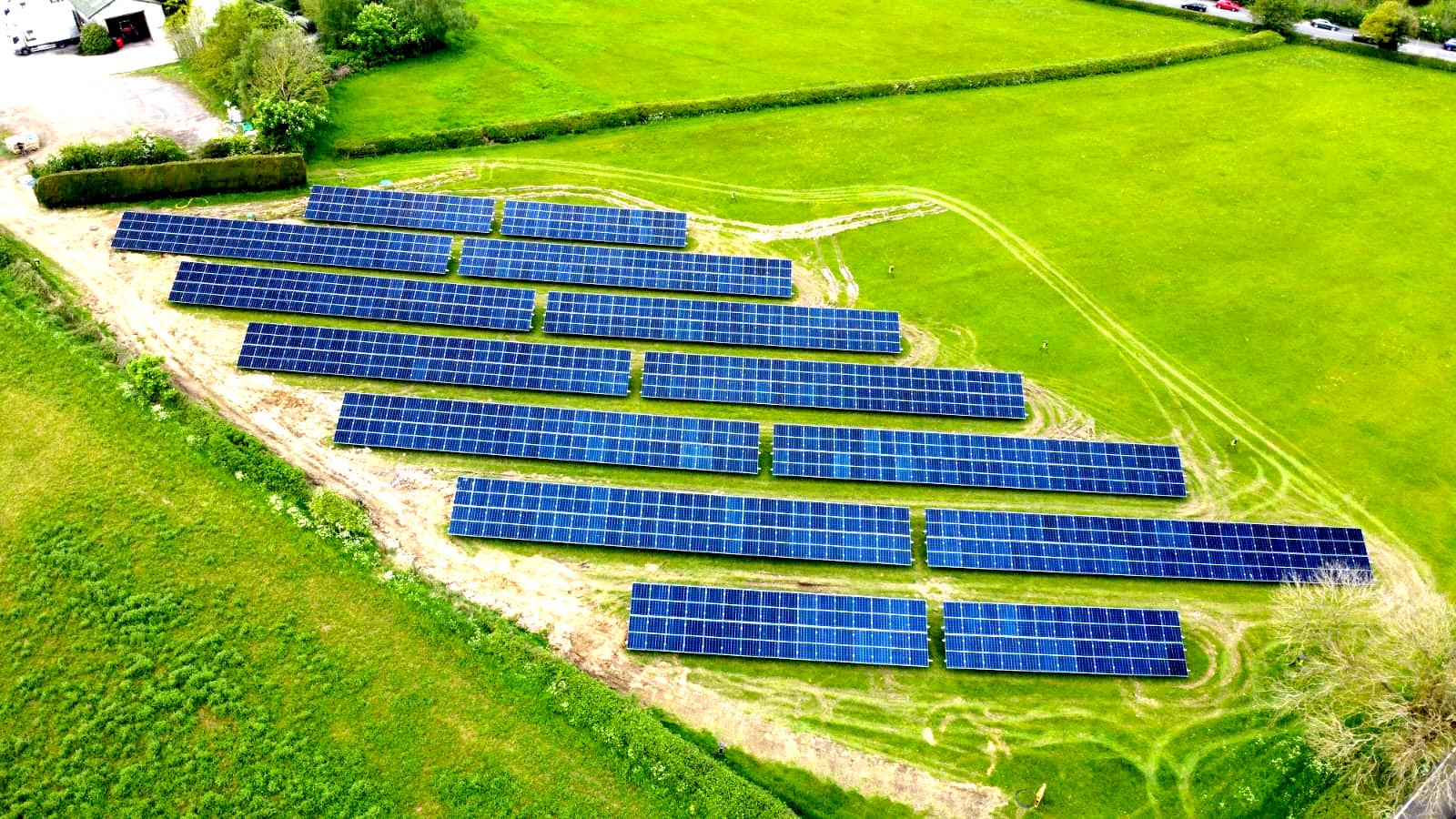 RB Elliott and Son solar panels aligned diagonally, seen from above in a vivid green field.