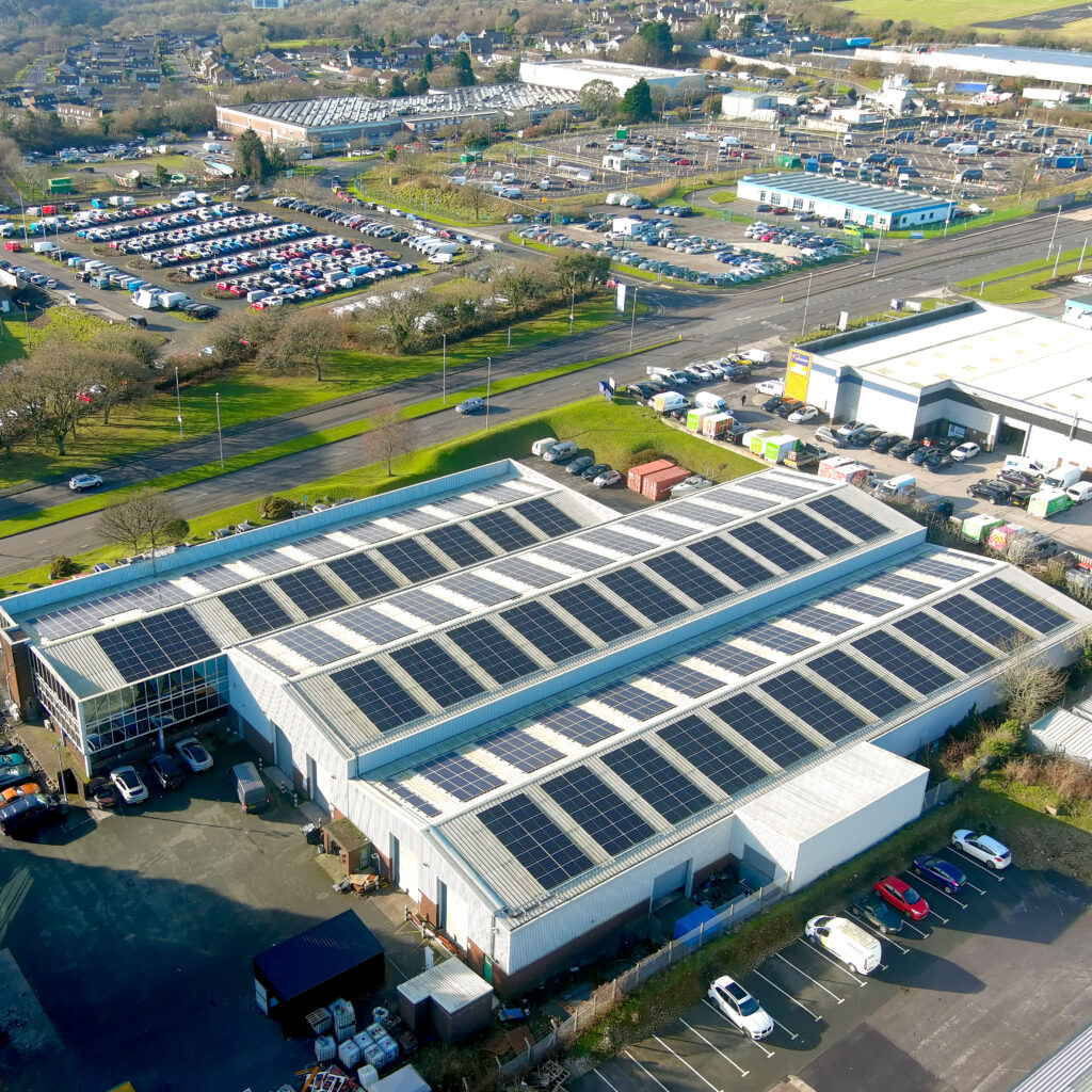 Roof of Hymec Aerospace with 600 solar panels, with buildings and cars in the background